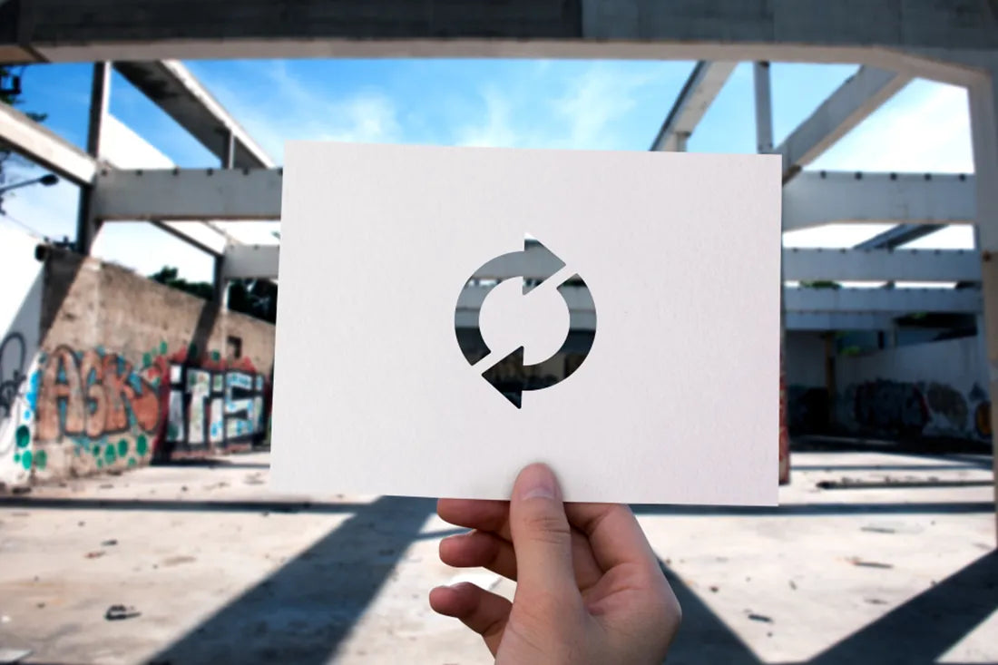 Papier mit ausgeschnittenem Loading Icon vor einem leeren Gebäude ohne Dach.
