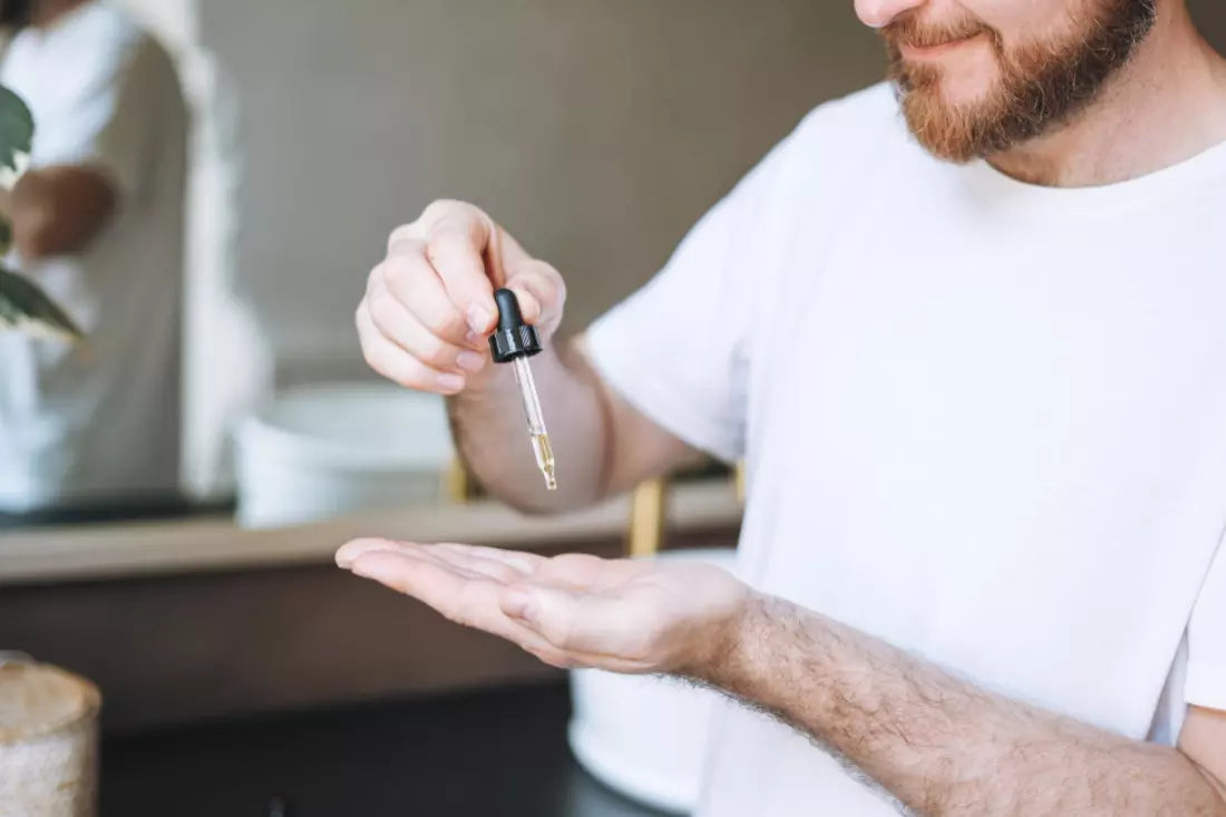 Man drips beard oil on his hand