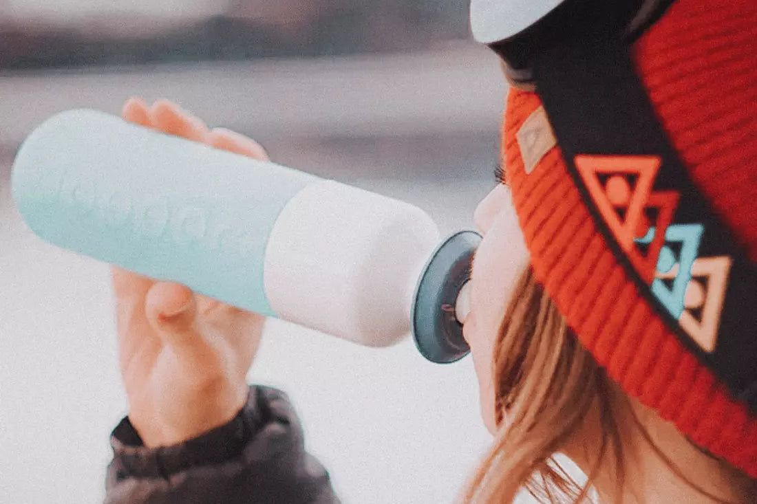 Woman drinks from fully recyclable Dopper bottle.