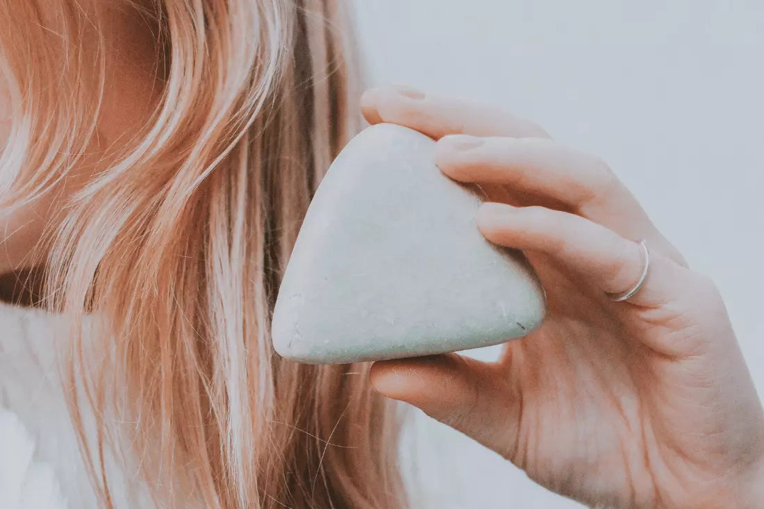 Blonde Person hält in einer Hand das plain b festes Shampoo Namastee - WingGuard.de