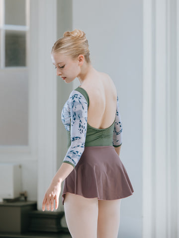 professional ballerina wearing a leotard stood in a ballet studio