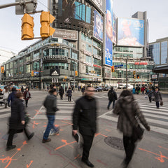 Busy city streets with people crossing intersection.