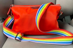 Colorful rainbow strap attached to a purse.