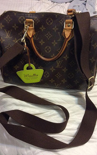 LV handbag with adjustable brown canvas strap.