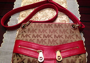 Michael Kors purse with matching red leather adjustable cross body strap.