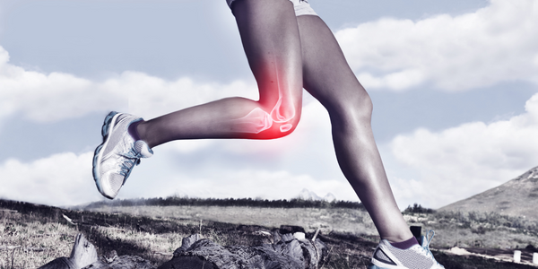 kvinna i ett löpsteg trots smärta på utsidan av knäet från löparknä