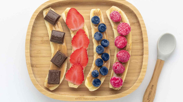 4 half bananas with a layer of peanut butter and one of the following toppings: Chocolate chunks or berries. Served on a bamboo baby plate