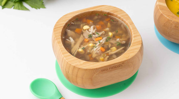 Clear chicken broth with vegetables served in an eco rascals bamboo bowl with spoon set