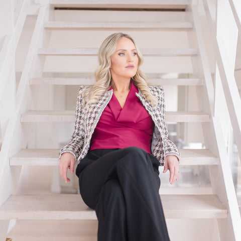 Brandi Gregge sitting at the bottom of a staircase.