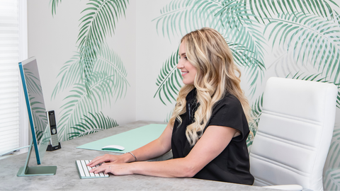 Brandi Gregge sitting in her office using a computer.