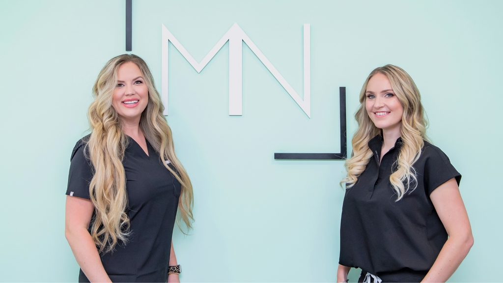 Valerie and Brandi smiling in front of the M&N logo.