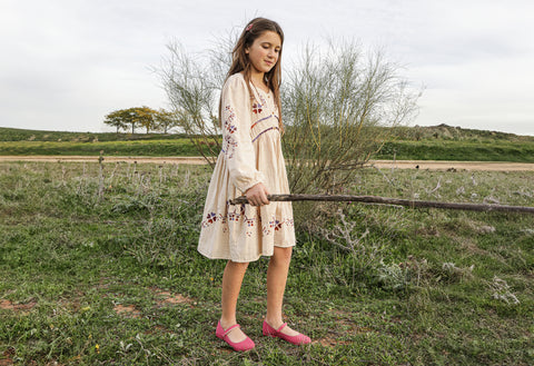 girl in prairie with fuxia canvas mary janes playing outdoors