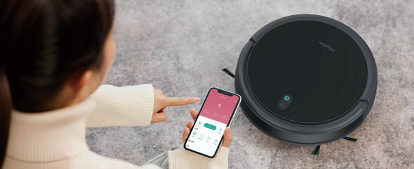 A person guiding you on how to use a robot vacuum cleaner using a phone