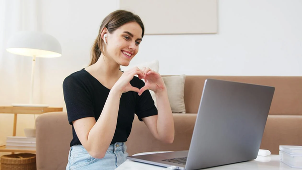 A Happy Lady on the computer using ANC Earbuds