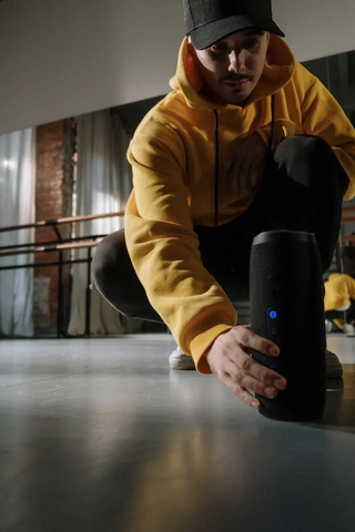 A Man turning ON his Bluetooth speaker