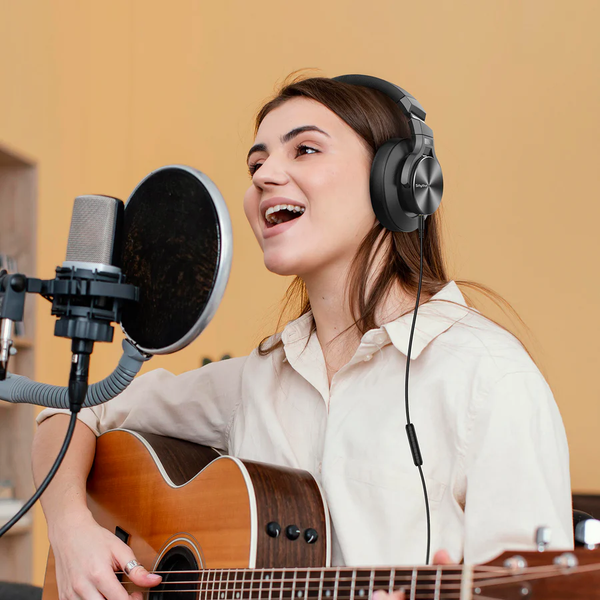 A Lady playing guitar and using HD Headphones