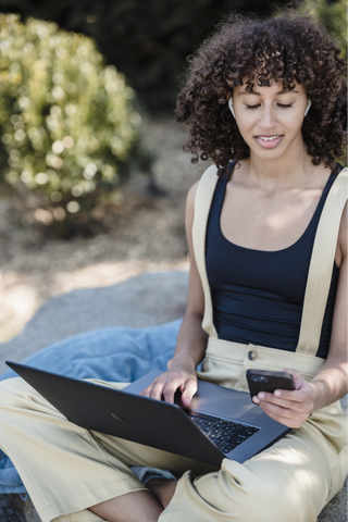 A student on the computer with ANC Earbuds