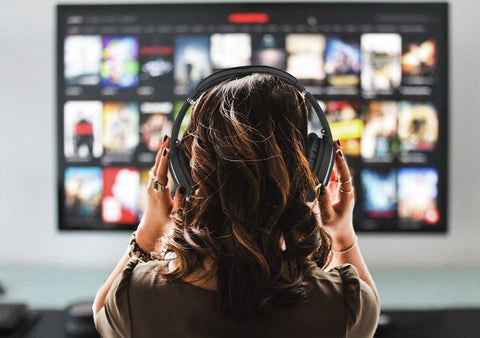 Girl watching TV wearing Srhythm headphones