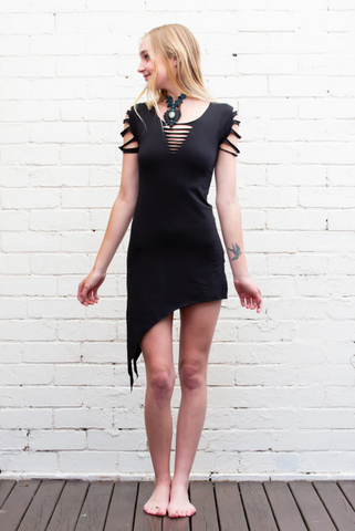 Model wearing a short black dress featuring an assymetrical cut