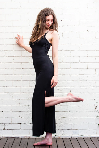 Model wearing a long dress with a low back cut in black colour