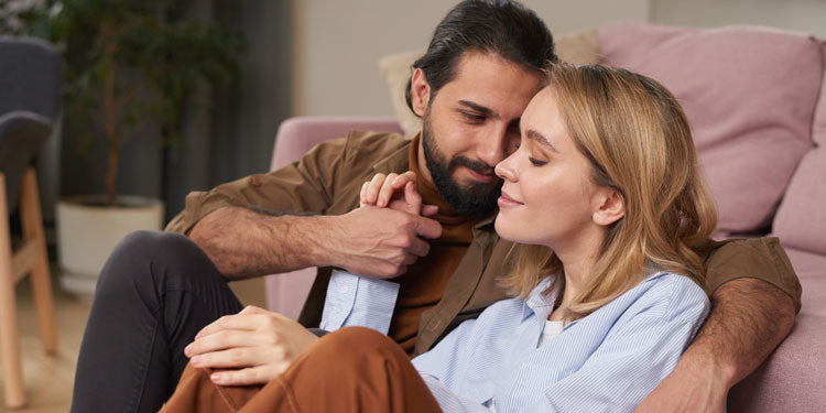 man and woman sitting on the floor, hugging and talking about something lovingly