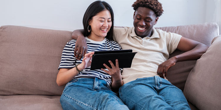 couple looking at their tablet and smiling