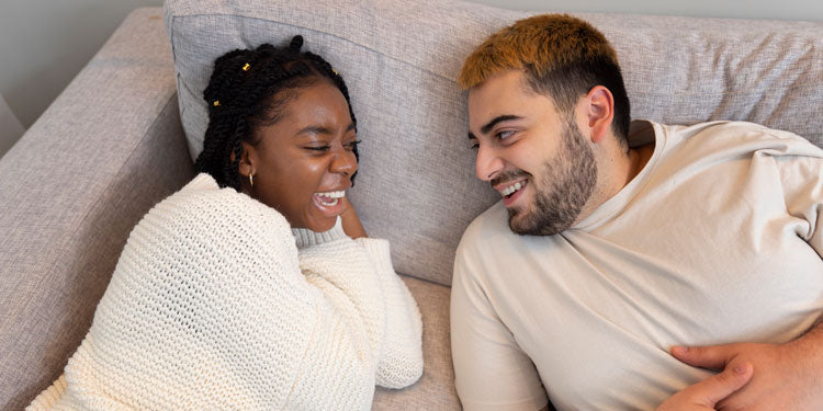 couple laying in bed, talking and having fun