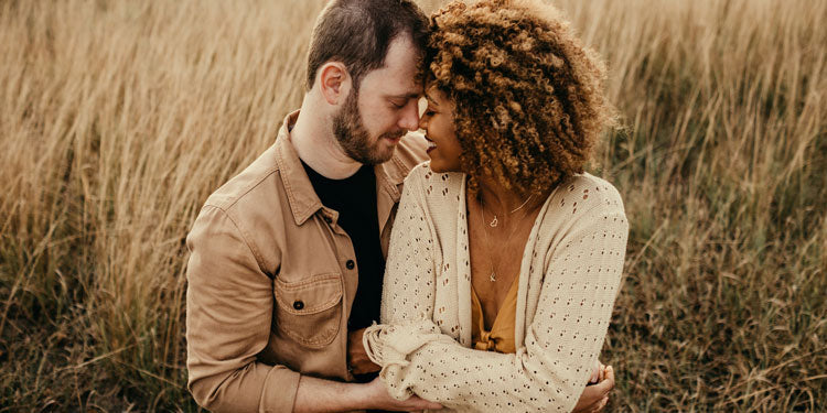 happy and kind couple hugging, tall grass behind