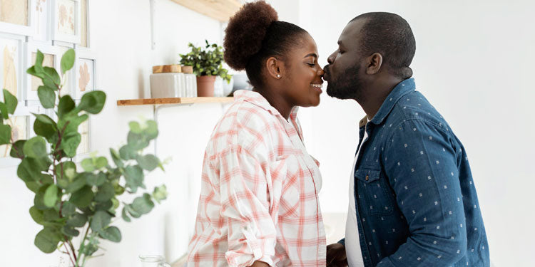 loving couple in their living room, the man kisses the woman, woman smiles