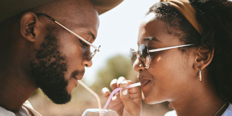 couple looking at each other and drinking a drink from a straw