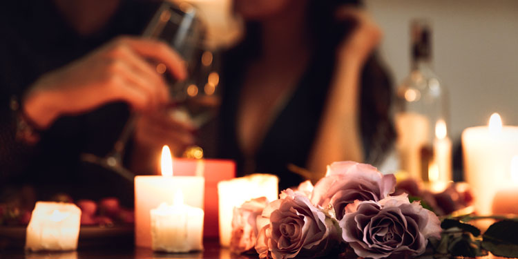 sensual atmosphere with scented candles and flowers, blurred couple in the background