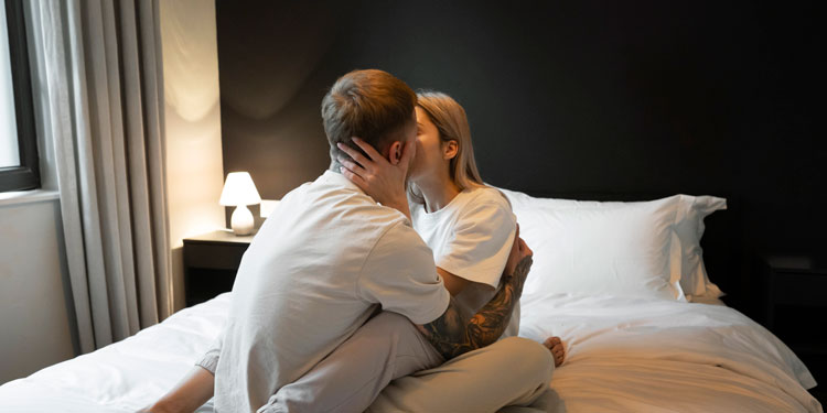 couple sitting in bed and kissing