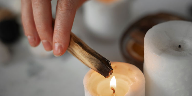 close up of lighting up an incense stick from a candle
