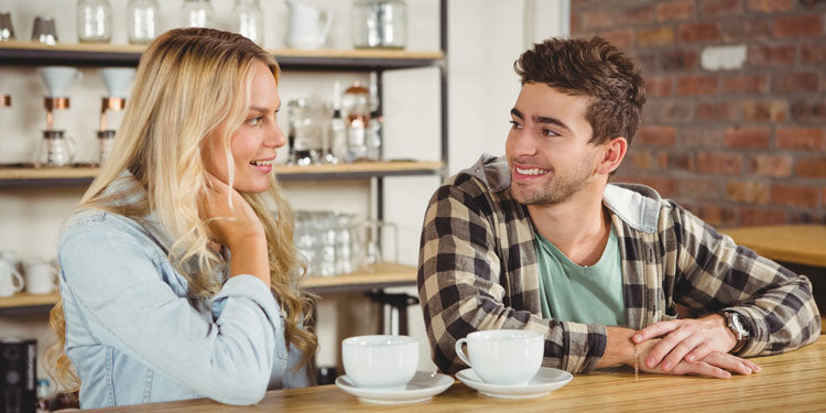 a young couple having a conversation while drinking coffee
