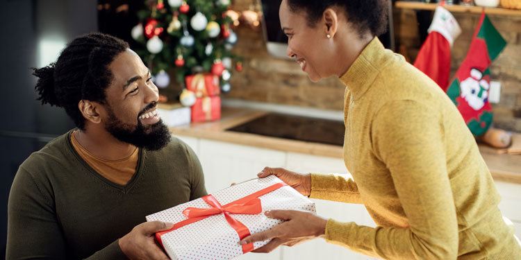 young couple surprising each other with Christmas gifts