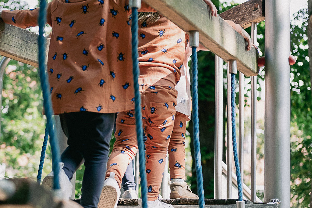 Kinder tragen die Kleidung der Käferkollektion