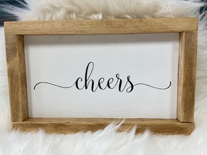 Cheers Wooden Sign  -White painted background with black lettering  -Frame stained in Early America  - Sign pictured is 10x5.5 and the frame will add approximately an inch.