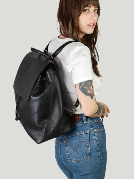 Model is wearing TAH Bags Commuter Backpack with white t-shirt and blue jeans