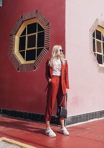 Woman wearing red pant suit with white sneakers and a casual white t-shirt