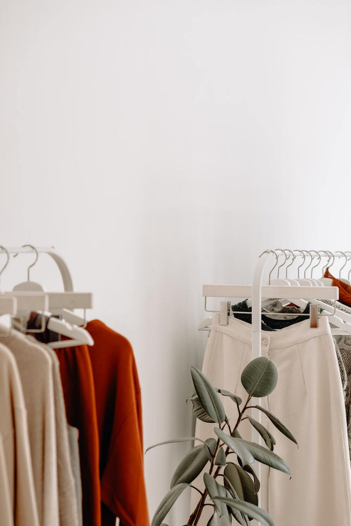 Clothing racks with red and beige tops and white pants