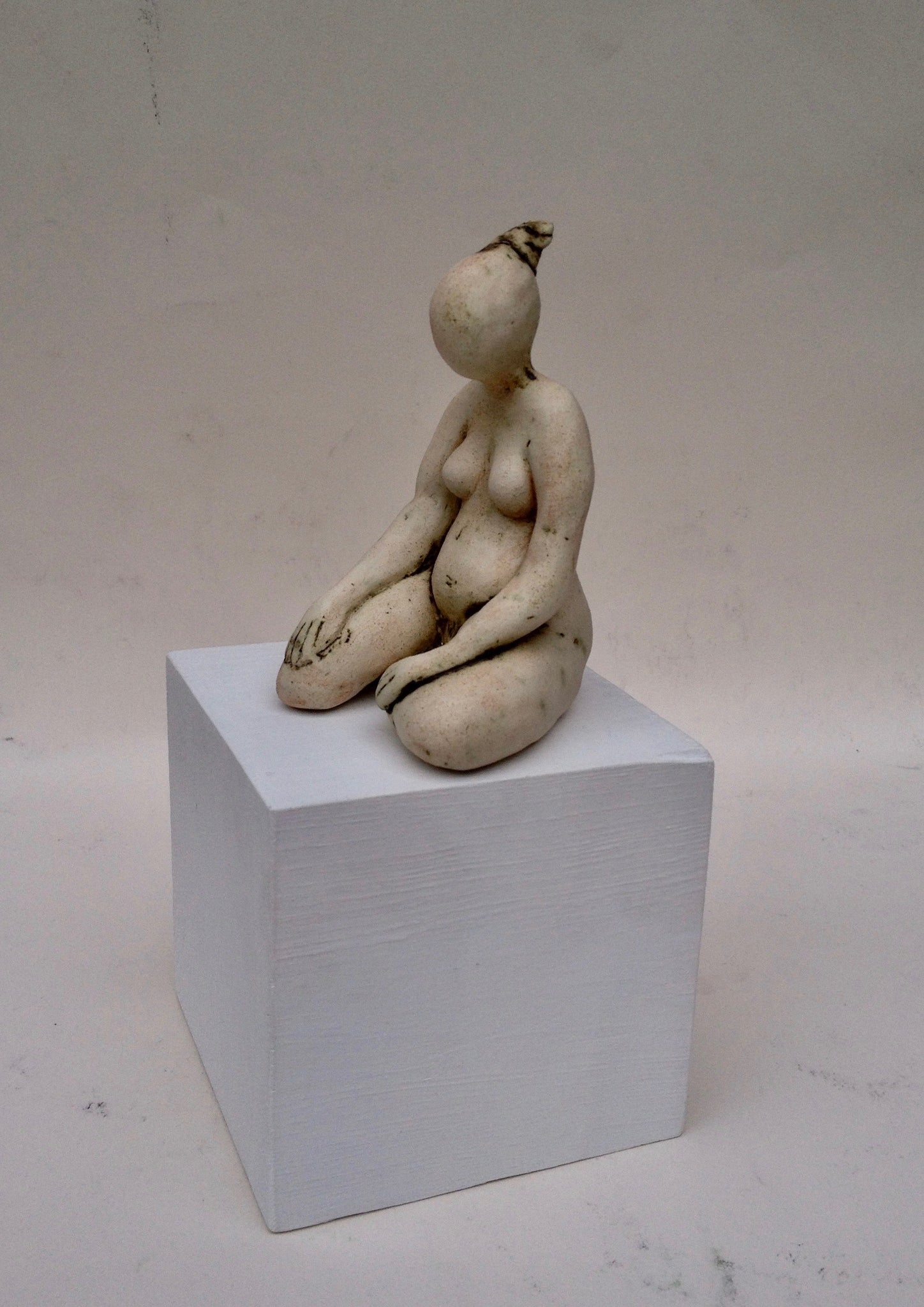 clay figurine on a white wooden cube by ceramic artist ruty benjamini