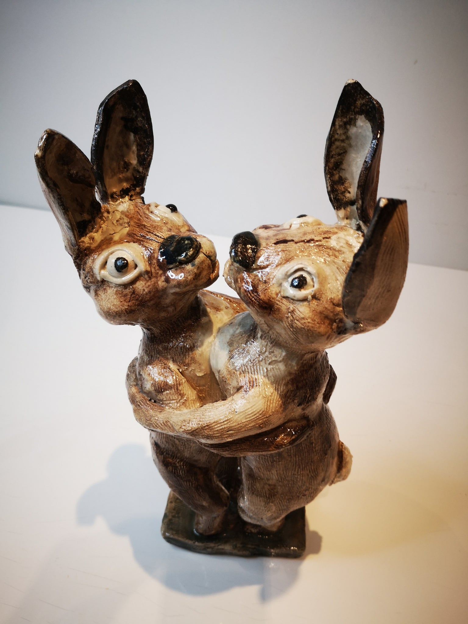Loving Hares, a ceramic sculpture of two hares hugging each other by ceramic artist Vivien Phelan
