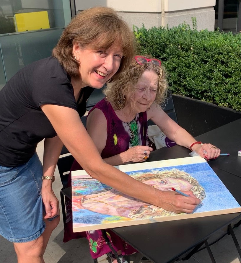 Stella Tooth signing the portrait of Marie for Age UK Ealing 