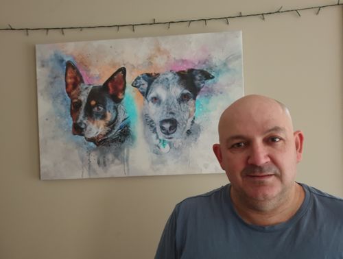 A customer standing in front of their custom pet portrait