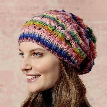 3/4 profile of a white woman wearing a colorful striped hat with an eyelet detail.