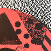 Close up of coral abstract screenprint with black and white textures.