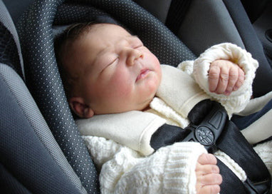 Sleeping newborn dressed in their baby's going home outfit.