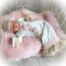 Newborn sleeping in their crib dressed in their baby's going home Outfit.