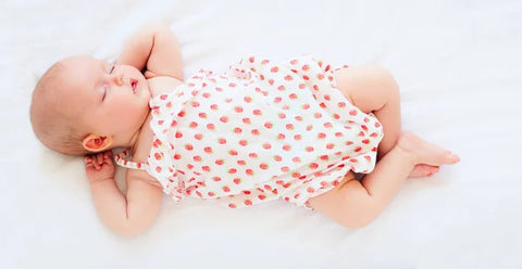 Newborn sleeping in her newborn hospital outfit.