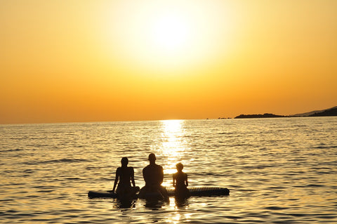 Family on an SUP at sunset